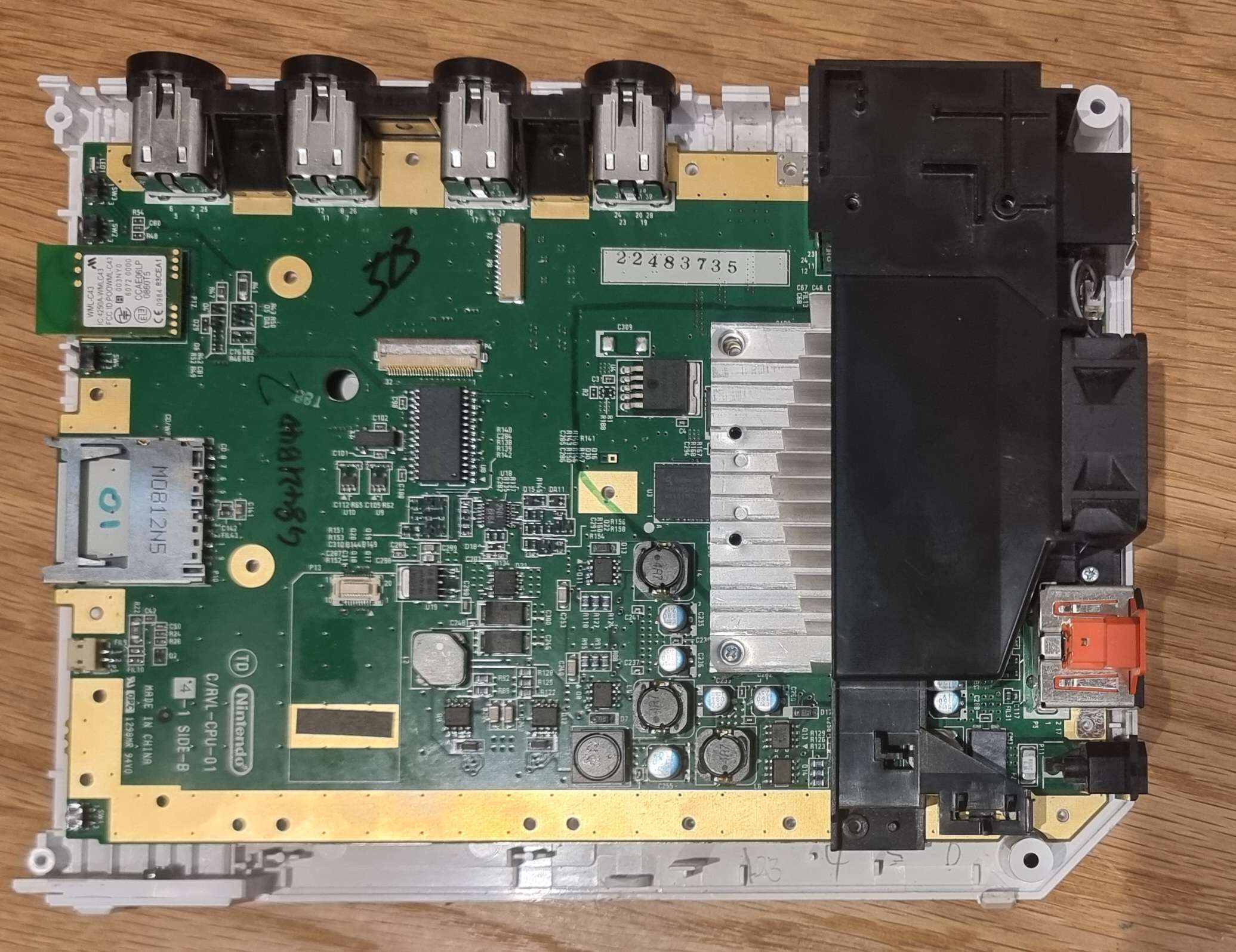 A photo of a Wii motherboard without the cover, with the heatsink attached.
