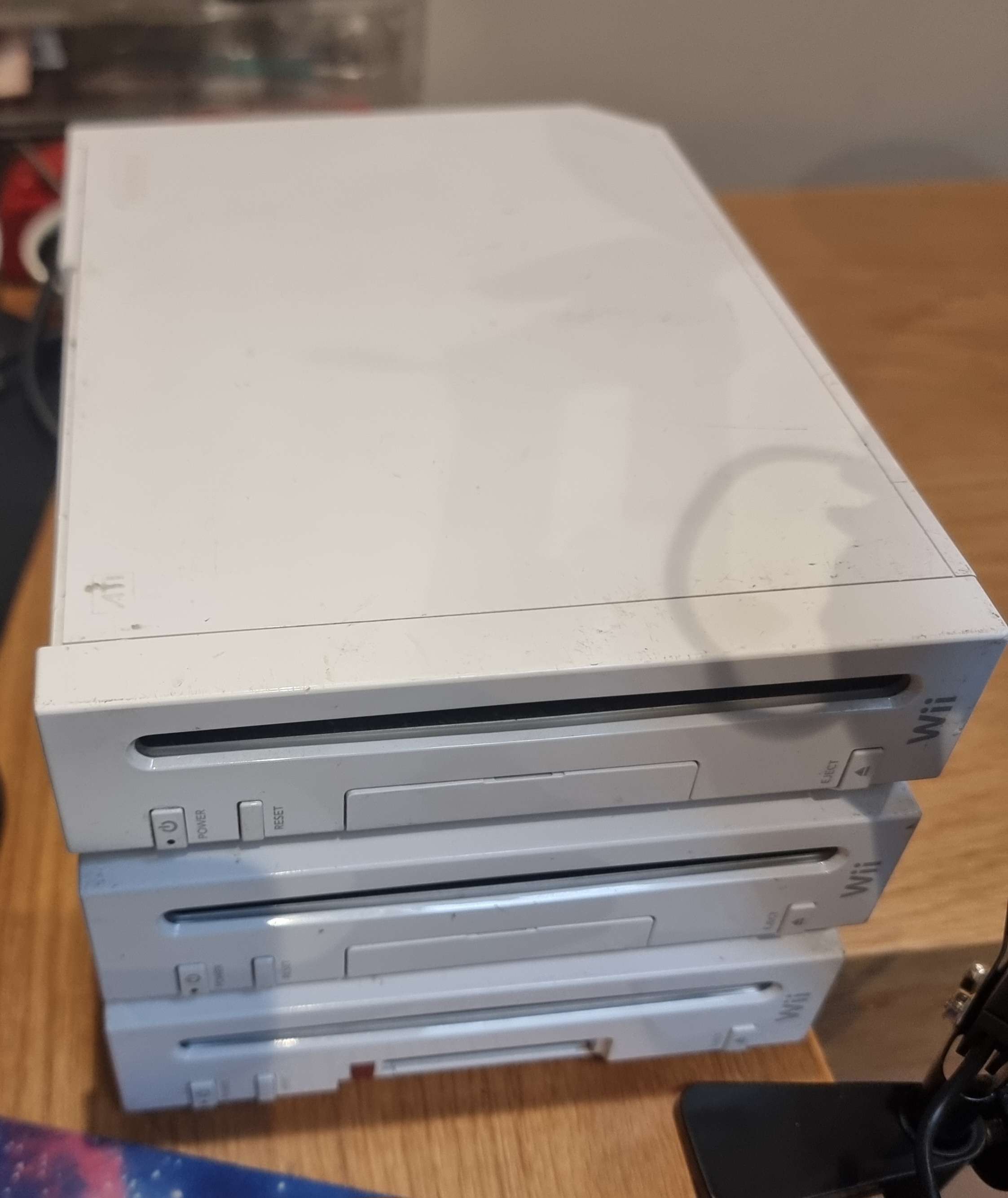 A photo of three Wii consoles stacked on top of each other.