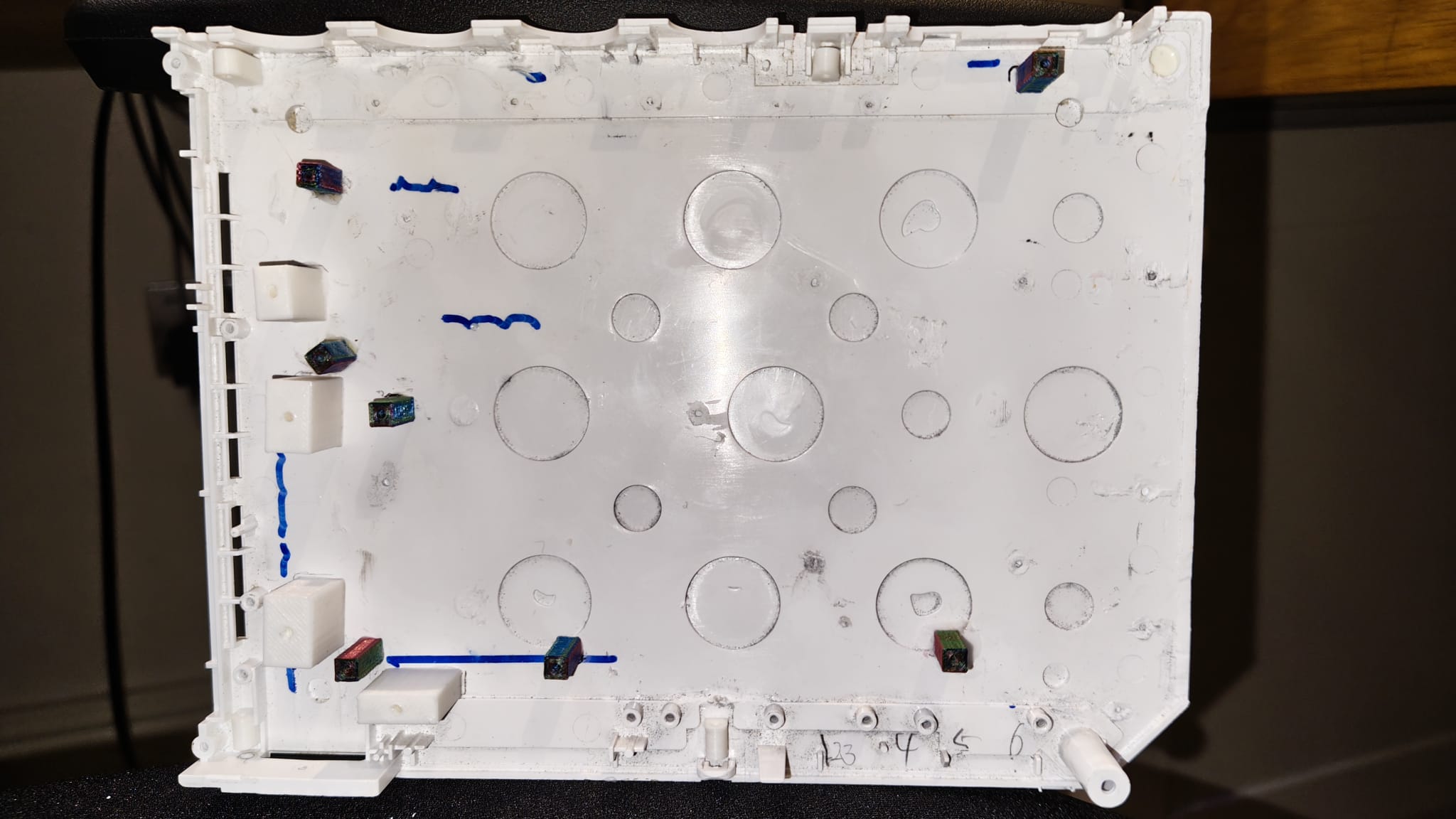 A photo of the bottom half of a Wii shell, with several standoffs attached.