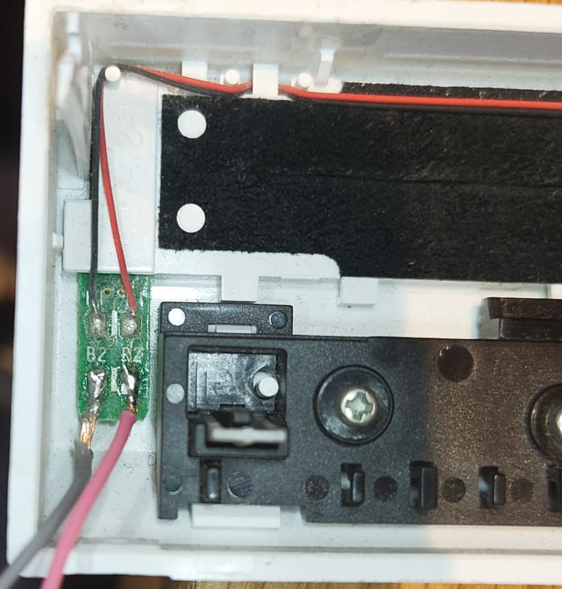 A photo of a small PCB with two red and two black wires connected to it