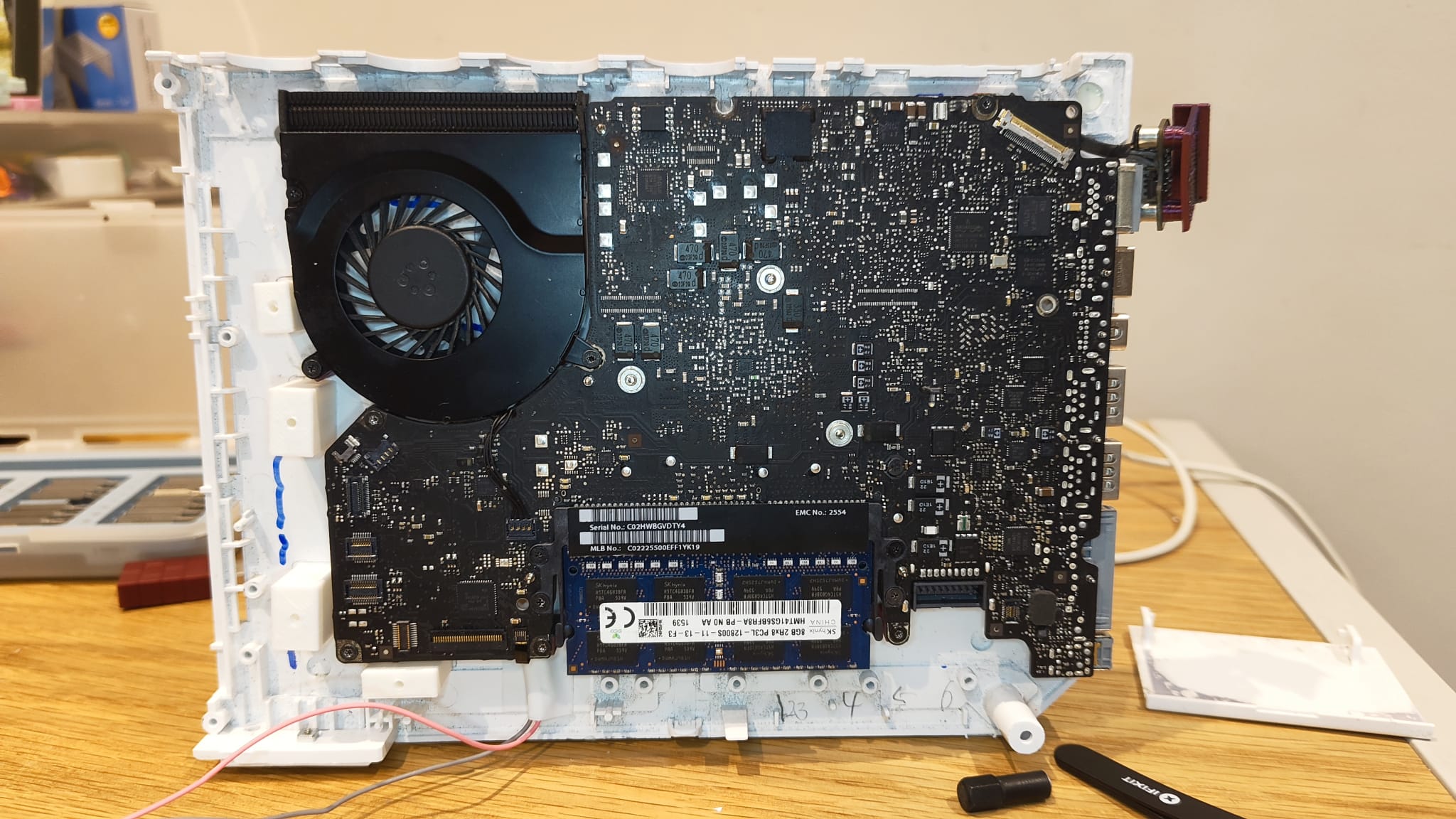 A photo of the bottom half of a Wii shell, with an old laptop motherboard seated on top of it.